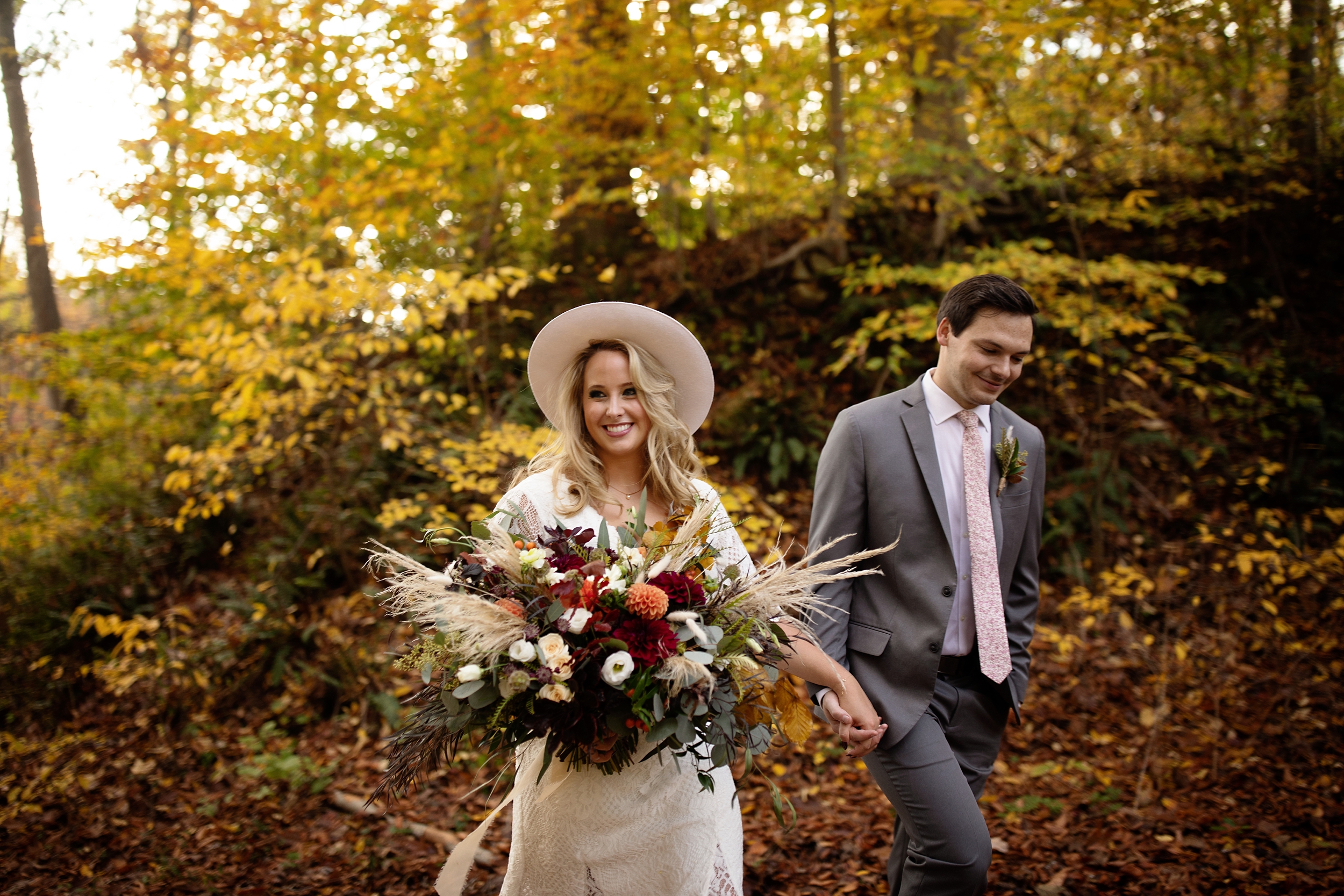 Boho Elopement at Hibernia Park in Coatsville, PA. macrame ceremony backdrop and whimsical, boho, dried florals. Bride is wearing a BHLD gown and a white hat.