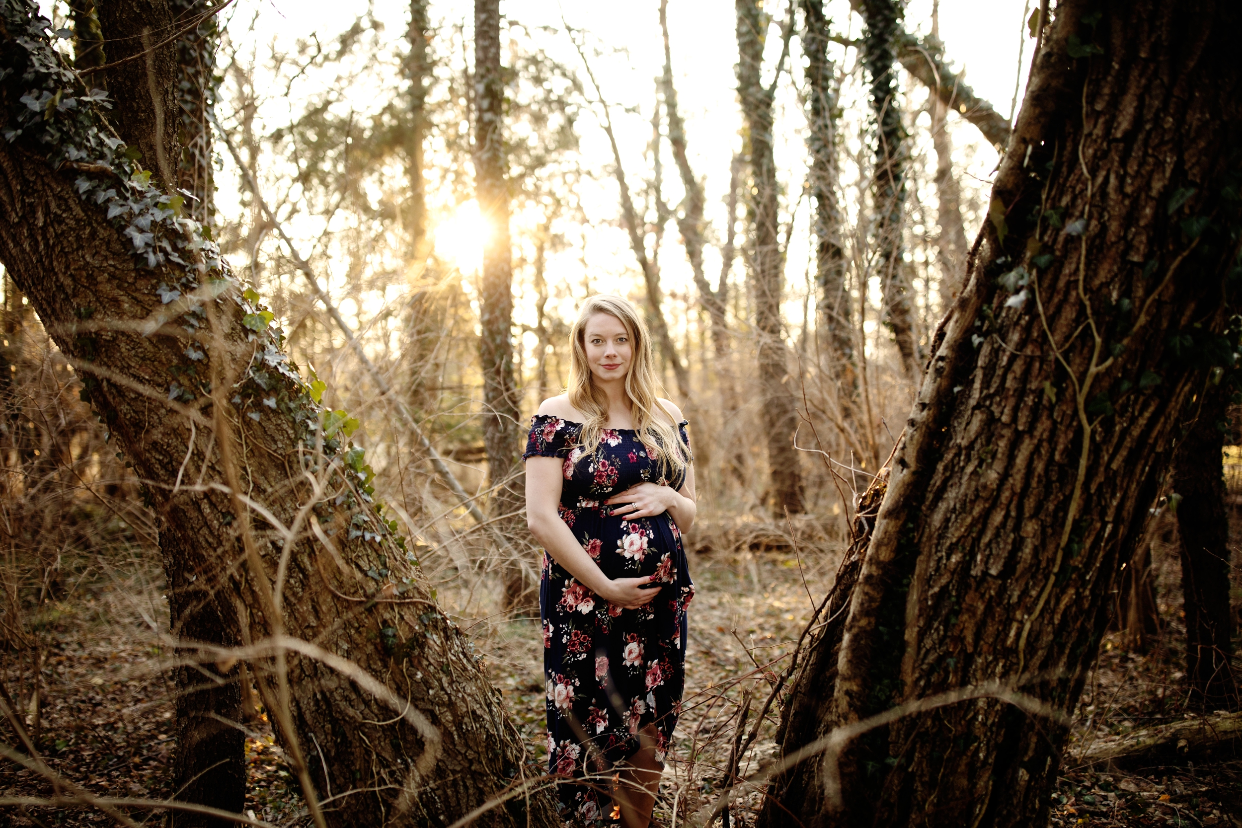A winter maternity photo session at golden hour in Lancaster PA at Overlook Park. Tall Evergreen trees and warm tones captured by Lancaster Photographer Janae Rose Photography